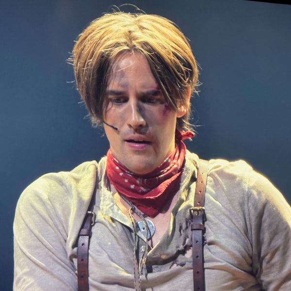Reeve Carney, one of the 5 original leads in Broadway's 8 Tony Award-winning musical, Hadestown,  in a scene from Hadestown, the Movie, wears fablesintheair.com Sterling Silver Carnival Token, one of 5 Hadestown "Easter Eggs" per Playbill Magazine.